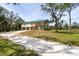 View of home with an attached garage, complemented by a long driveway and lush trees at 1526 Maytown Rd, Oak Hill, FL 32759