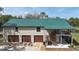 Exterior of home with a green roof and an attached garage with three bays at 1526 Maytown Rd, Oak Hill, FL 32759