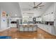 Modern kitchen featuring white cabinets, a large center island, stainless steel appliances, and hardwood floors at 1526 Maytown Rd, Oak Hill, FL 32759
