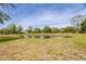 Scenic view of a peaceful pond surrounded by lush greenery under a blue sky at 1526 Maytown Rd, Oak Hill, FL 32759