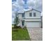 Charming two-story home with a well-maintained lawn, a two-car garage, and a teal front door at 1904 Diamond Head Cir, Lake Hamilton, FL 33851