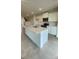 White kitchen island featuring quartz countertops, a stainless steel sink and ample cabinet space at 1904 Diamond Head Cir, Lake Hamilton, FL 33851