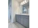 Bathroom featuring gray cabinets, modern fixtures, double sinks, and tile flooring at 1908 Diamond Head Cir, Lake Hamilton, FL 33851