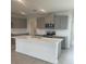 Modern kitchen with gray cabinets, stainless steel appliances, and a center island with quartz countertops at 1908 Diamond Head Cir, Lake Hamilton, FL 33851
