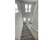 Carpeted staircase with white railing leading to the lower level at 1908 Diamond Head Cir, Lake Hamilton, FL 33851
