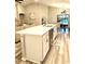 Open-concept kitchen featuring white cabinets, an island with breakfast bar, and modern appliances at 2000 Golden Beak Dr, Eagle Lake, FL 33839