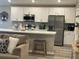 Modern kitchen featuring white cabinets, stainless steel appliances, and a breakfast bar at 2000 Golden Beak Dr, Eagle Lake, FL 33839