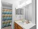 Bathroom featuring wooden vanity, white tile, mirror, shower with patterned curtain and toilet at 2808 Revere Ct, Casselberry, FL 32707
