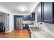 Beautiful kitchen with stainless appliances, granite counters, and custom blue cabinetry at 2808 Revere Ct, Casselberry, FL 32707
