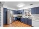 Updated kitchen features blue cabinets, stainless steel appliances, and granite countertops at 2808 Revere Ct, Casselberry, FL 32707