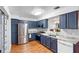 Updated kitchen features blue cabinets, stainless steel appliances, and granite countertops at 2808 Revere Ct, Casselberry, FL 32707