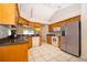 Kitchen with wood cabinets, stainless steel appliances and black countertops, with views out to the lanai at 2924 Jebidiah Loop, St Cloud, FL 34772