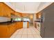 Kitchen with wood cabinets, black countertops, and stainless steel appliances overlooking a breakfast nook and views of the lanai at 2924 Jebidiah Loop, St Cloud, FL 34772