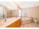 Main bathroom with double vanity, large tub, and walk-in shower at 2924 Jebidiah Loop, St Cloud, FL 34772