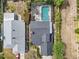 Aerial view of a single-Gathering home with a dark roof and screened-in pool at 3001 Little Cypress Cv, Winter Park, FL 32792