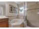 Bathroom with tub, glass shower, and decorative framed wall art above the tub at 3001 Little Cypress Cv, Winter Park, FL 32792