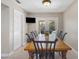 Bright dining area features a wooden table, black chairs, and sliding glass doors leading to the pool area at 3001 Little Cypress Cv, Winter Park, FL 32792