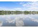 Scenic view of a lake reflecting the sky, bordered by lush trees and residential homes at 3001 Little Cypress Cv, Winter Park, FL 32792
