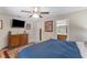 Primary bedroom with a ceiling fan, dresser, tv, and ensuite bathroom, plus hardwood floors and plenty of light at 3001 Little Cypress Cv, Winter Park, FL 32792
