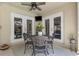 Covered outdoor patio featuring a ceiling fan, TV, and an ornate metal table with seating for four at 3001 Little Cypress Cv, Winter Park, FL 32792