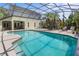 Enjoy this screened backyard pool surrounded by tropical plants and lounge chairs at 3001 Little Cypress Cv, Winter Park, FL 32792