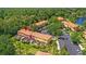 Aerial view of homes with orange tile roofs in a community near a lake at 3064 Yellow Lantana Ln, Kissimmee, FL 34747