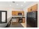 Well-lit kitchen featuring black appliances, dark countertops, and eat-in breakfast bar at 3064 Yellow Lantana Ln, Kissimmee, FL 34747