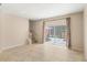 Bright living room featuring tile flooring, neutral walls, and sliding glass doors to the outdoor area at 3064 Yellow Lantana Ln, Kissimmee, FL 34747