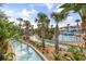 Tranquil lazy river winds through lush landscaping, palm trees, and resort amenities for a relaxing water experience at 3118 Magic Kingdom Ct, Kissimmee, FL 34746