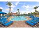 Resort pool area with palm trees, lounge chairs, and clear blue water, ideal for relaxation at 3118 Magic Kingdom Ct, Kissimmee, FL 34746