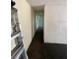 This is a hallway with a ladder, white walls, and damaged flooring at 31647 Mount Plymouth Loop, Sorrento, FL 32776