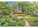 Backyard garden with stone path, decorative plants, mature trees and privacy fence at 3332 Stonewood Ct, Orlando, FL 32806