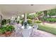Covered patio features tile flooring, white wicker furniture and ceiling fans, with lush backyard views at 3332 Stonewood Ct, Orlando, FL 32806