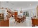 Bright dining room featuring tile floors, wooden staircase, and a chandelier, perfect for hosting memorable gatherings at 3332 Stonewood Ct, Orlando, FL 32806