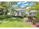 A picturesque view of the home's side exterior, highlighting the lush greenery, manicured lawn, and architectural details at 3332 Stonewood Ct, Orlando, FL 32806