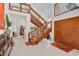 Grand foyer with a distinctive wooden staircase, glass railings, and double front doors, creating an elegant entryway at 3332 Stonewood Ct, Orlando, FL 32806
