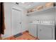 Functional laundry room with washer, dryer, and shelving for storage, on terracotta tile at 3332 Stonewood Ct, Orlando, FL 32806