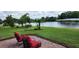 Scenic backyard view with lush lawn, pond, and patio seating; perfect for outdoor enjoyment at 3998 Bedford Ave, Winter Haven, FL 33884