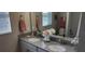 Bathroom featuring double sinks, granite countertops, and a large mirror at 3998 Bedford Ave, Winter Haven, FL 33884