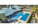 Aerial view of a community pool with a clubhouse, tennis court, and lush landscaping at 3998 Bedford Ave, Winter Haven, FL 33884