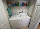 Functional laundry room with a washer, dryer, storage shelf, and closet at 4012 King Edward Dr, Orlando, FL 32826