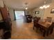 Open-concept living and dining area with tile floors, modern lighting, and access to a screened patio at 4012 King Edward Dr, Orlando, FL 32826