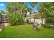 Green backyard with lush lawn and seating area, enclosed with trees and white fencing at 4119 Pecan Ln, Orlando, FL 32812