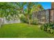 Spacious backyard with lush green lawn and enclosed patio with a screened-in enclosure at 4119 Pecan Ln, Orlando, FL 32812