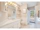 Bright bathroom featuring a double sink vanity, sleek white tile floors and glass shelves at 4119 Pecan Ln, Orlando, FL 32812