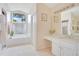 Light-filled bathroom featuring soaking tub, tile floors, and dual vanities with ample counter space at 4119 Pecan Ln, Orlando, FL 32812