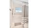 Clean bathroom with tub/shower combination with gray and white striped shower curtain and white tile at 4119 Pecan Ln, Orlando, FL 32812