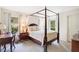 Cozy bedroom featuring a four-poster bed, two windows, and classic decor at 4119 Pecan Ln, Orlando, FL 32812