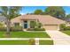 Charming single-story home featuring lush lawn, mature trees, and a blue front door at 4119 Pecan Ln, Orlando, FL 32812