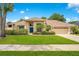 Charming single-story home features a well-manicured lawn, a blue front door, and attached two-car garage at 4119 Pecan Ln, Orlando, FL 32812